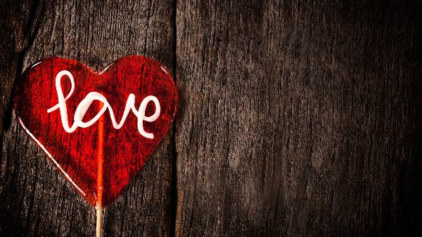 Love lollipop on dark old wooden background
